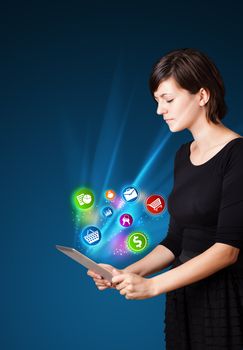 Young business woman looking at modern tablet with abstract lights and various icons