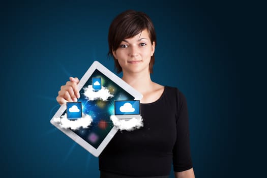 Beautiful young woman holding tablet with modern devices in clouds