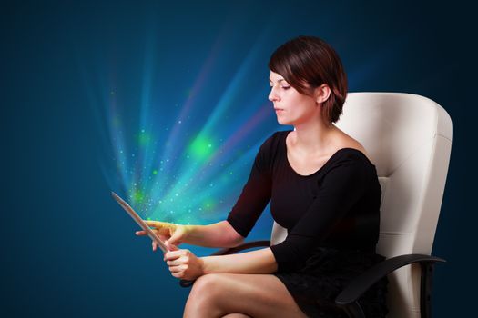 Young business woman looking at modern tablet with abstract lights 