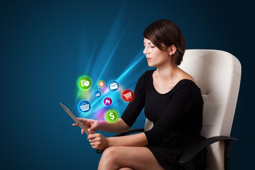 Young business woman looking at modern tablet with abstract lights and various icons