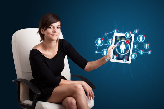 Beautiful young woman holding tablet with social network icons