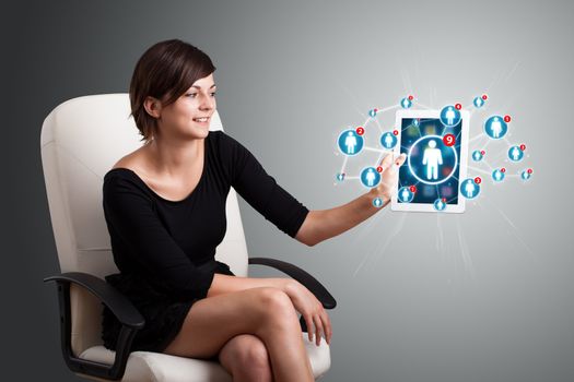 Beautiful young woman holding tablet with social network icons