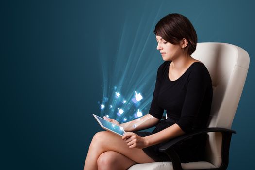 Young business woman looking at modern tablet with abstract lights and social icons