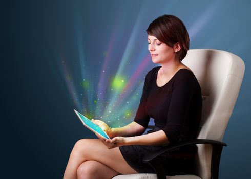 Young business woman looking at modern tablet with abstract lights 