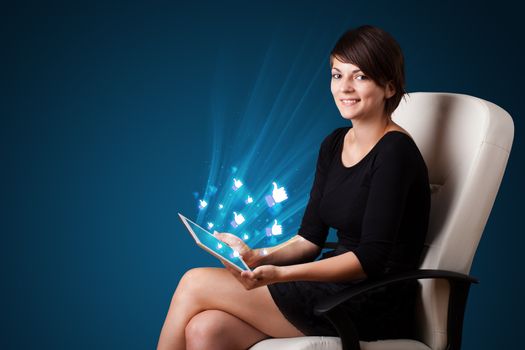 Young business woman looking at modern tablet with abstract lights and social icons