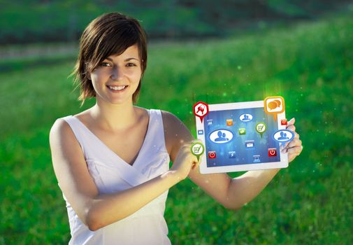 Young business woman looking at modern tablet with abstract lights and social icons