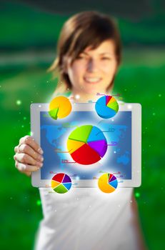 Young business woman looking at modern tablet with abstract light and various diagrams