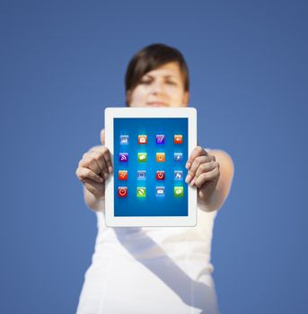 Young business woman looking at modern tablet with abstract lights and various icons