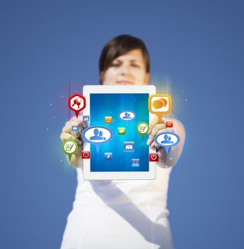 Young business woman looking at modern tablet with abstract lights and social icons