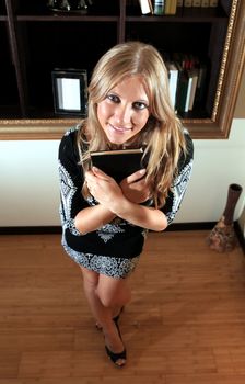 sight of happy undergraduate with black book near bookshelf