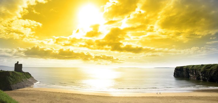 panorama of a Beautiful yellow sun over the Ballybunion beach and castle in Ireland one summers day
