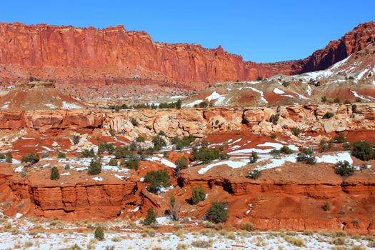 Patches of snow amidst the red rock scenery of Capitol Reef National Park in Utah.