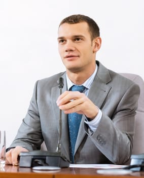 Portrait of a businessman, said into the microphone, the meeting