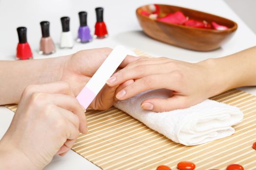 Young woman is getting manicure in a beauty salon