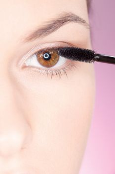 Close up of a woman applying mascara on eye