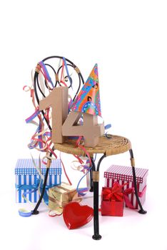 Number of age in a colorful studio setting with paper party hat and figures, a red heart and gifts