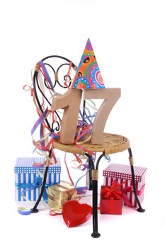 Number of age in a colorful studio setting with paper party hat and figures, a red heart and gifts