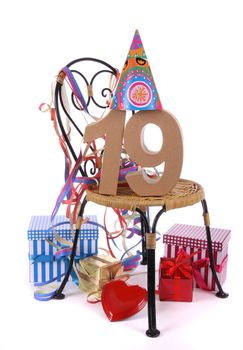 Number of age in a colorful studio setting with paper party hat and figures, a red heart and gifts