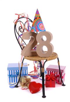 Number of age in a colorful studio setting with paper party hat and figures, a red heart and gifts