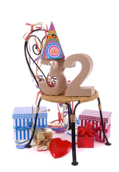 Number of age in a colorful studio setting with paper party hat and figures, a red heart and gifts
