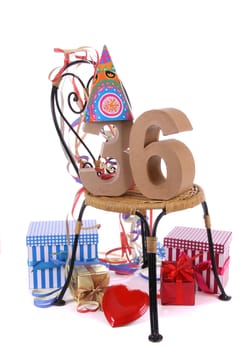Number of age in a colorful studio setting with paper party hat and figures, a red heart and gifts