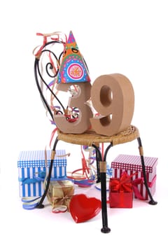 Number of age in a colorful studio setting with paper party hat and figures, a red heart and gifts