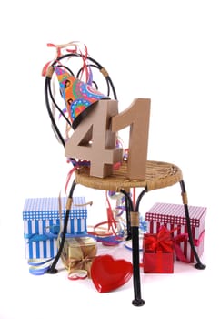 Number of age in a colorful studio setting with paper party hat and figures, a red heart and gifts