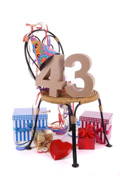 Number of age in a colorful studio setting with paper party hat and figures, a red heart and gifts