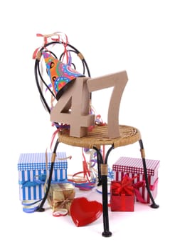 Number of age in a colorful studio setting with paper party hat and figures, a red heart and gifts