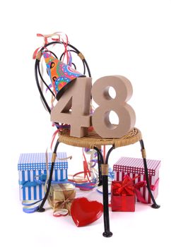 Number of age in a colorful studio setting with paper party hat and figures, a red heart and gifts