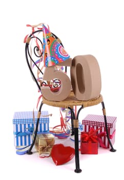 Number of age in a colorful studio setting with paper party hat and figures, a red heart and gifts