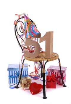 Number of age in a colorful studio setting with paper party hat and figures, a red heart and gifts