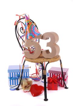 Number of age in a colorful studio setting with paper party hat and figures, a red heart and gifts