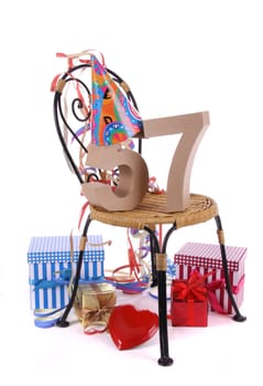 Number of age in a colorful studio setting with paper party hat and figures, a red heart and gifts