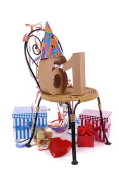 Number of age in a colorful studio setting with paper party hat and figures, a red heart and gifts