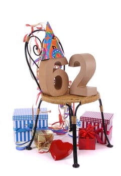 Number of age in a colorful studio setting with paper party hat and figures, a red heart and gifts