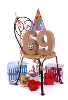 Number of age in a colorful studio setting with paper party hat and figures, a red heart and gifts