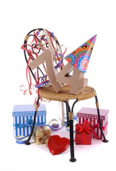 Number of age in a colorful studio setting with paper party hat and figures, a red heart and gifts