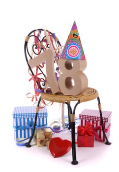 Number of age in a colorful studio setting with paper party hat and figures, a red heart and gifts