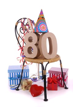 Number of age in a colorful studio setting with paper party hat and figures, a red heart and gifts