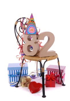 Number of age in a colorful studio setting with paper party hat and figures, a red heart and gifts