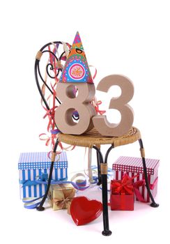 Number of age in a colorful studio setting with paper party hat and figures, a red heart and gifts