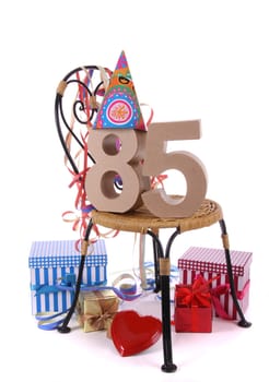 Number of age in a colorful studio setting with paper party hat and figures, a red heart and gifts