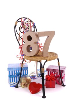 Number of age in a colorful studio setting with paper party hat and figures, a red heart and gifts
