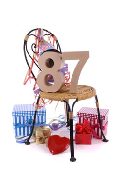 Number of age in a colorful studio setting with paper party hat and figures, a red heart and gifts