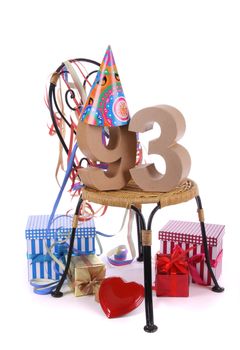 Number of age in a colorful studio setting with paper party hat and figures, a red heart and gifts