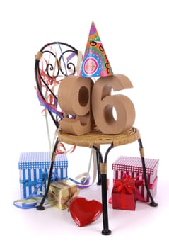 Number of age in a colorful studio setting with paper party hat and figures, a red heart and gifts