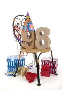 Number of age in a colorful studio setting with paper party hat and figures, a red heart and gifts