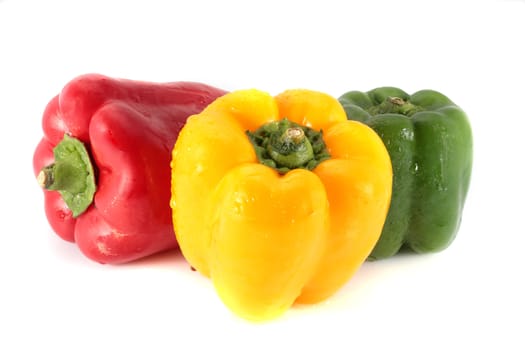 three red peppers and green yellow isolated on white