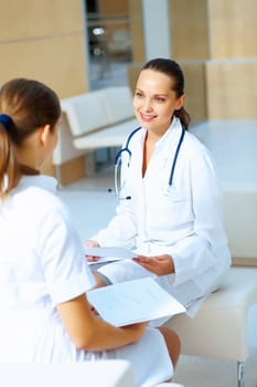 Portrait of two friendly female doctors in hospital discussing something